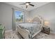 Cozy bedroom with natural light, a queen-sized bed, and a bedside table with lamp at 3544 Monfero Ave, North Port, FL 34286