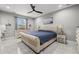 Bright bedroom featuring neutral walls, stylish fan, an upholstered bed, and a patterned accent rug at 3544 Monfero Ave, North Port, FL 34286