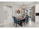 The dining room features a wood table, blue chairs, modern lighting, and french doors to the outside at 3544 Monfero Ave, North Port, FL 34286