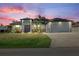 Charming home features a spacious two-car garage and a well-manicured lawn at dusk at 3544 Monfero Ave, North Port, FL 34286