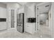 A kitchen with stainless steel refrigerator, white cabinets, and pantry door with decorative glass and adjacent bedroom at 3544 Monfero Ave, North Port, FL 34286