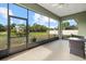 Enclosed patio with a glass table set offers views of the spacious backyard at 3544 Monfero Ave, North Port, FL 34286