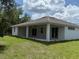 The home has a covered patio and a grassy backyard at 384 Prineville St, Port Charlotte, FL 33954