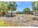 Exterior view of a home with a charming backyard featuring palm trees, an outdoor kitchen, and a wooden pergola at 3927 Vasco St, Punta Gorda, FL 33950