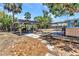 Shot of the backyard featuring multiple lounge areas, an outdoor kitchen, wooden pergola and beautiful, mature landscaping at 3927 Vasco St, Punta Gorda, FL 33950