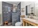 Stylish renovated bathroom featuring blue tiled shower, unique wooden stool and modern fixtures at 3927 Vasco St, Punta Gorda, FL 33950