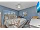 Cozy blue bedroom with natural light from two windows and queen sized bed at 3927 Vasco St, Punta Gorda, FL 33950