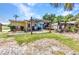 Exterior shot of the home featuring an outdoor kitchen, a wooden pergola and a well-maintained lawn at 3927 Vasco St, Punta Gorda, FL 33950
