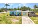 Single-story home features colorful exterior, mature palm trees, and a concrete driveway at 3927 Vasco St, Punta Gorda, FL 33950