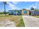 Single-story home features colorful exterior, mature palm trees, and a concrete driveway at 3927 Vasco St, Punta Gorda, FL 33950