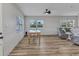 Open-concept living room with wood floors, ceiling fan, and lots of natural light at 3927 Vasco St, Punta Gorda, FL 33950