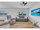 Living room with wood flooring, ceiling fan, sofa, recliner, and large-screen TV at 3927 Vasco St, Punta Gorda, FL 33950