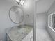 The bathroom features a circular mirror, new light fixture and granite countertop at 4243 Hokan Ave, North Port, FL 34287