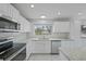 Bright kitchen features modern stainless appliances, granite countertops, and sleek white cabinetry at 4243 Hokan Ave, North Port, FL 34287
