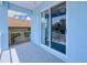 Bright covered balcony features a sliding glass door and white railing overlooking trees and a neighboring rooftop at 4285 Oak Terrace Cir, Port Charlotte, FL 33953