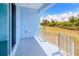 Blue covered balcony with white railing overlooking trees and a manicured yard at 4285 Oak Terrace Cir, Port Charlotte, FL 33953