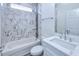 Modern bathroom featuring marble-look tile in the shower, a white vanity, and chrome fixtures at 4285 Oak Terrace Cir, Port Charlotte, FL 33953
