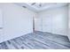 Spacious bedroom features grey wood floors, two closets, and a contemporary ceiling fan and lighting at 4285 Oak Terrace Cir, Port Charlotte, FL 33953
