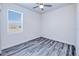 Bright bedroom with gray wood-look flooring, base trim, and natural light from a window at 4285 Oak Terrace Cir, Port Charlotte, FL 33953