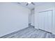 Bright bedroom featuring a ceiling fan, closet, and stylish gray wood-look flooring at 4285 Oak Terrace Cir, Port Charlotte, FL 33953