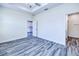 Comfortable bedroom features grey wood floors, a doorway to the kitchen, and a modern ceiling fan at 4285 Oak Terrace Cir, Port Charlotte, FL 33953