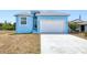 Charming light blue single-Gathering home featuring a two-car garage and manicured lawn at 4285 Oak Terrace Cir, Port Charlotte, FL 33953