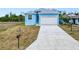 Charming blue home exterior with a two car garage and well-manicured landscaping at 4285 Oak Terrace Cir, Port Charlotte, FL 33953