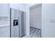 Stainless steel refrigerator beside an open doorway to the pantry with wire shelving at 4285 Oak Terrace Cir, Port Charlotte, FL 33953