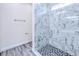 Modern shower features mosaic floor tiles, a glass enclosure, and marble-look wall tiles at 4285 Oak Terrace Cir, Port Charlotte, FL 33953