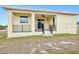Exterior of the house with a covered patio and black railings overlooking the backyard at 4290 Oak Terrace Cir, Port Charlotte, FL 33953