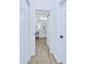 Hallway view of a bathroom with a white vanity, sleek fixtures, and modern wood-look flooring at 4290 Oak Terrace Cir, Port Charlotte, FL 33953