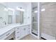 Bathroom featuring a white vanity with quartz countertop, decorative lighting and glass enclosed shower at 4290 Oak Terrace Cir, Port Charlotte, FL 33953