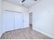 This bedroom offers light woodgrain flooring, closet and bright white walls at 4290 Oak Terrace Cir, Port Charlotte, FL 33953