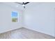 Bright bedroom with a large window, ceiling fan, and stylish light woodgrain flooring at 4290 Oak Terrace Cir, Port Charlotte, FL 33953