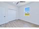 Bedroom with wood-look flooring, closet and a window providing view of backyard at 4290 Oak Terrace Cir, Port Charlotte, FL 33953