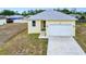 Exterior shot of a light yellow home with a white garage door and a simple front yard at 4290 Oak Terrace Cir, Port Charlotte, FL 33953