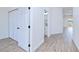 This hallway offers light woodgrain flooring, closet space and access to the bathroom at 4290 Oak Terrace Cir, Port Charlotte, FL 33953
