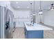 Modern kitchen features stainless steel refrigerator, white cabinetry, an island with a sink, and pendant lighting at 4290 Oak Terrace Cir, Port Charlotte, FL 33953