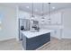 Bright kitchen features white cabinets, stainless appliances, center island with quartz countertop and modern pendant lighting at 4290 Oak Terrace Cir, Port Charlotte, FL 33953