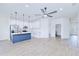 Open concept living space with white walls, modern ceiling fan, light wood-look flooring and kitchen view at 4290 Oak Terrace Cir, Port Charlotte, FL 33953