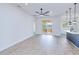 Spacious living room with light woodgrain floors, a sliding glass door to the backyard, and a modern ceiling fan at 4290 Oak Terrace Cir, Port Charlotte, FL 33953