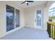 A peaceful outdoor patio featuring a ceiling fan, white door, and sliding glass door at 4290 Oak Terrace Cir, Port Charlotte, FL 33953