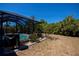 Backyard with a barbecue and screened-in pool area surrounded by mature tropical trees at 4339 Boggs St, Port Charlotte, FL 33948