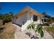 Charming home exterior featuring landscaped yard with decorative stone and mature tropical plants under a clear, blue sky at 4339 Boggs St, Port Charlotte, FL 33948
