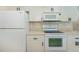Kitchen features white cabinets, white appliances and light counter tops at 4339 Boggs St, Port Charlotte, FL 33948