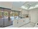 Bright kitchen with white cabinetry and marble floors, offering views of the pool area at 4339 Boggs St, Port Charlotte, FL 33948