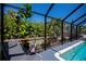 Enclosed pool with chair seating and landscaped garden views at 4339 Boggs St, Port Charlotte, FL 33948