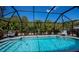Inviting screened-in pool area with comfortable lounge chairs and lush landscaping at 4339 Boggs St, Port Charlotte, FL 33948