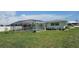 View of backyard with a screened-in pool, surrounding landscaping, and the home's exterior at 570 Mimosa Nw Ave, Port Charlotte, FL 33952