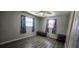 Bedroom featuring wood-look floors, two windows with curtains, and minimalist furniture at 570 Mimosa Nw Ave, Port Charlotte, FL 33952